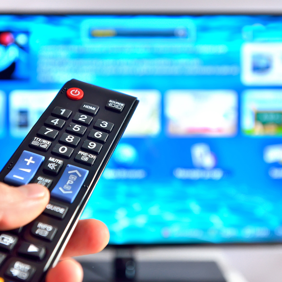 Image of a person pointing a remote at a tv